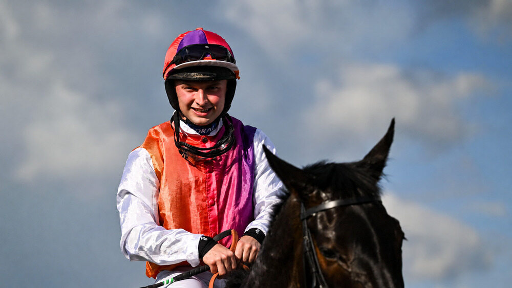 Sean Bowen riding a National Hunt racehorse with both hands on the reins.